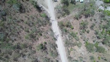İnsansız hava araçları, düz tozlu bir yol boyunca kampçılarla dolu bir tekne rampasına ve tuz düzlüklerine giden derenin yukarısından görüntüler alıyor.