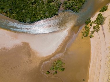 Düşük gelgit ve kumdaki desenlerle bir adaya yapılan küçük tropik kıyı arazisinin insansız hava aracı manzarası.