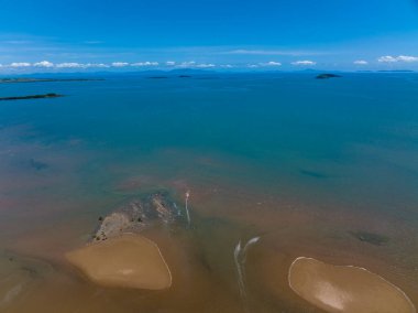 Deniz yatağının insansız hava yolları alçak gelgitte ve mavi ufkun ötesine bakıyor.