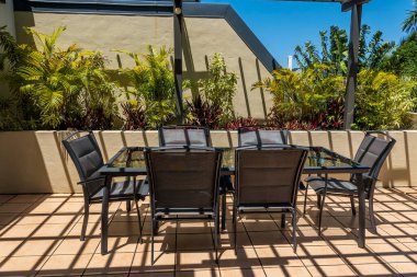 Güvertede örgü örülmüş bir masa mobilyaların üzerine gölgeler bırakıyor.