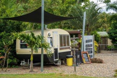 Airlie Beach, queensland, Australia - January 2022: A quaint caravan coffee shop with numerous directional signs and menu in a country garden setting
