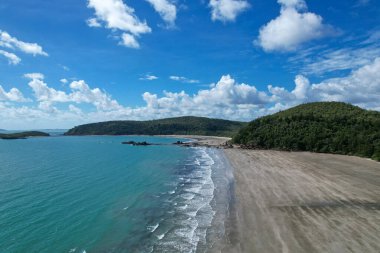 Dalgaların alçaldığı kumsalda açık mavi bulutlu gökyüzü Cape Hillsborough Avustralya insansız hava aracı manzarası