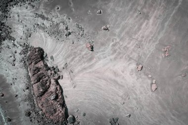 Alçak gelgitte kayalık bir plajın insansız hava aracı tarafından tepeden aşağı bakılıyor.