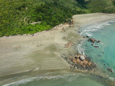 Tropikal sahilde dalgalanan kayalar