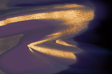 Parlak metalik altın kıvrımları koyu bir arkaplanı vurguluyor. Lüks dijital arkaplan.