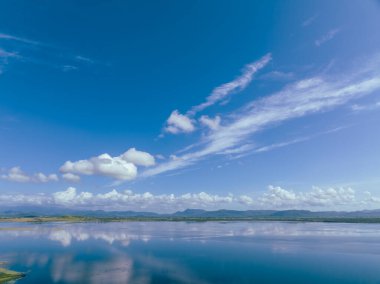 Sıcak bir yaz gününde Avustralya 'daki bir barajın sakin sularında bulutlar yansıdı..