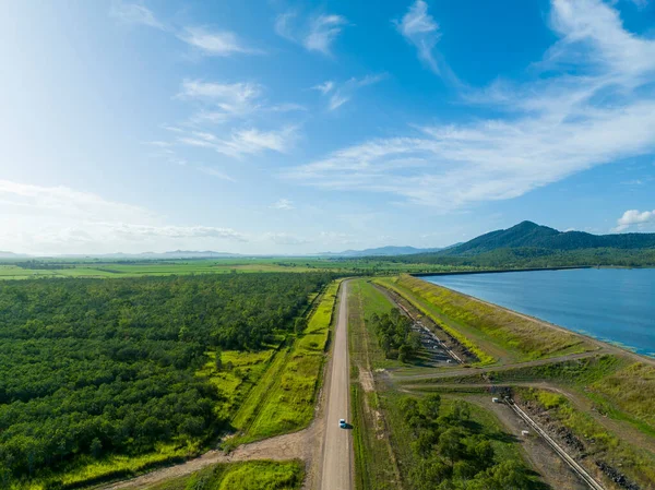 Yanında bir araba olan baraj duvarının havadan görüntüsü. Huzurlu köy manzarası. Kinchant Barajı, Queensland, Avustralya.