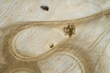 Tuz tabakalarının üzerinden geçen soyut bir lastik izi örneği. İnce taneli çökeltideki havadan görünüşlü drone..