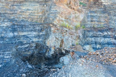 Taş ocağında kazılarak yol yapımında endüstriyel kullanıma dönüştürülüyor. Kaya tabakaları görünür..