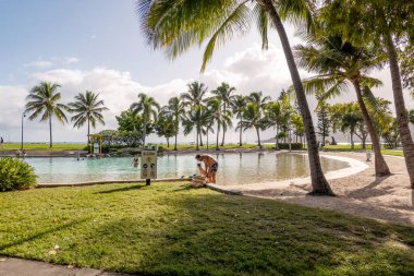 Airlie Beach, WhitSunday, Queensland, Avustralya - Nisan 2022: Parkland 'da halk gölünde yüzmekten keyif alan insanlar.