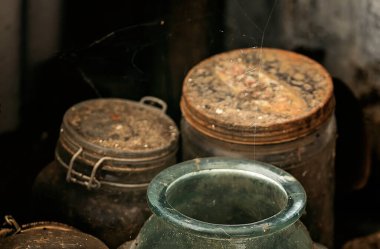 Eski bir safir madenci kulübesinin karanlık bir köşesinde saklı eski şişeler. Önplanda yeşil cam, kasıtlı olarak bulanık arkaplan.