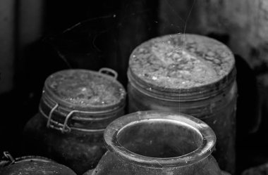 Eski bir safir madenci kulübesinin karanlık bir köşesinde saklı eski şişeler. Önplanda yeşil cam, kasıtlı olarak bulanık arkaplan.