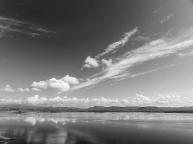 Sıcak bir yaz gününde Avustralya 'daki bir barajın sakin sularında bulutlar yansıdı..
