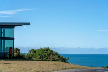 Bowen, Queensland, Avustralya 'daki muhteşem mavi okyanus kıyı manzarası önünde telefonuyla oynayan tanımlanamayan bir turist..