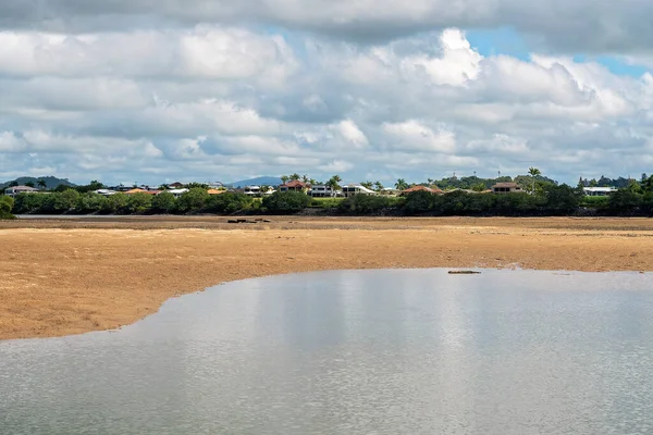Tuzlu su nehrinin karşısına ve deniz çekilince kumla karşı kıyıdaki evlere doğru bakıyorum. Şehrin içinden akan mavi bir su nehri.