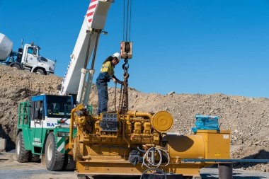 Mackay, Queensland, Australia - 7th June 2022: Worker on machinery in a quarry producing industrial rock and stone for construction of roads and other purposes.