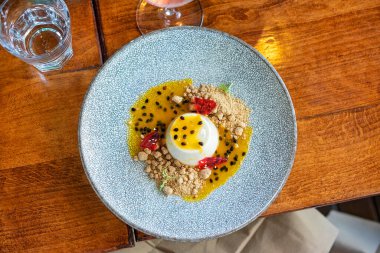 Üzüm bağı restoranındaki mavi bir tabakta meyveli turta ve tutku dolu bir tatlı..