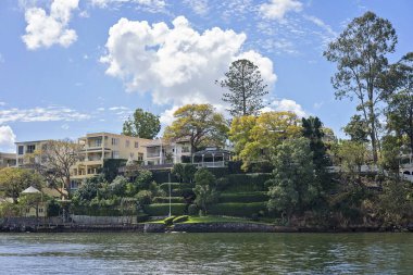 Brisbane, Queensland, Avustralya - Eylül 2022: Nehir kıyısındaki lüks evler kendi tekne iskeleleriyle. Nehir manzarası, zengin zenginler için pahalı bir yaşam tarzı..