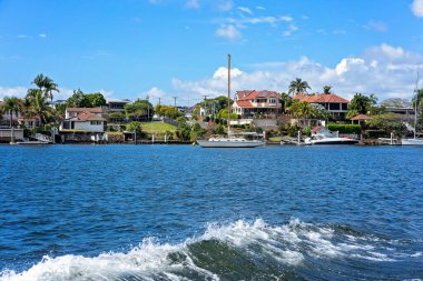 Brisbane, Queensland, Avustralya - Eylül 2022: Nehir kıyısındaki lüks evler kendi tekne iskeleleriyle. Nehir manzarası, zengin zenginler için pahalı bir yaşam tarzı..
