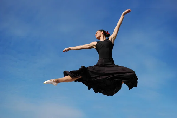 Ballerina jumpimp contro cielo blu — Foto Stock