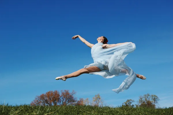 Dansare jumpimp mot blå himmel — Stockfoto