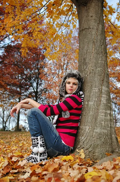 Menina bonita descansando contra uma árvore — Fotografia de Stock