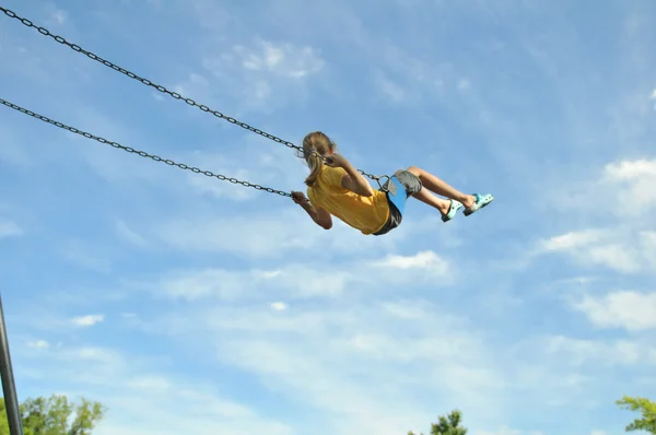 Молода дівчина на гойдалці на блакитному небі — стокове фото