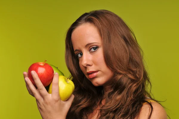 Mujer joven sosteniendo manzanas — Foto de Stock