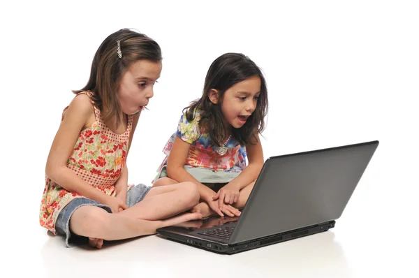 Dos niñas pequeñas con un ordenador portátil — Foto de Stock