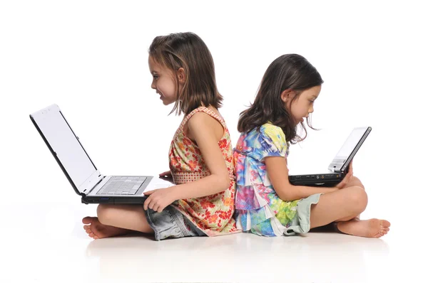 Две маленькие девочки с ноутбуками — стоковое фото