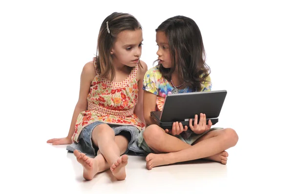 Dos niñas pequeñas con un ordenador portátil — Foto de Stock