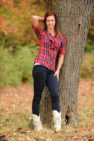 Young Woman standing by a tree — Stockfoto