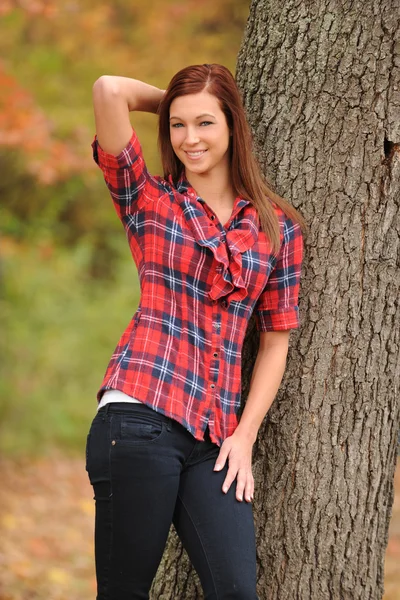 Młoda kobieta stojąc przez drzewa — Zdjęcie stockowe