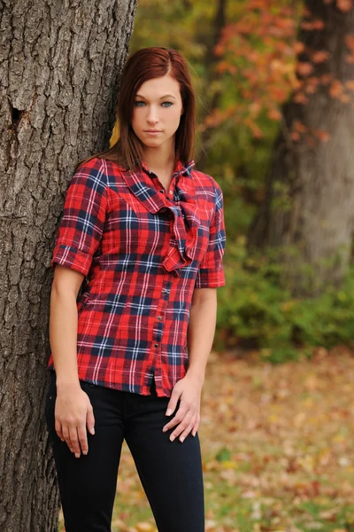 Young Woman standing by a tree — Stock Photo, Image
