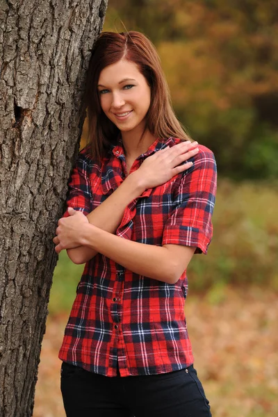 Young Woman standing by a tree Stock Photo