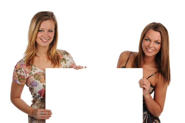 Zwei schöne junge Frauen mit einem leeren Schild — Stockfoto