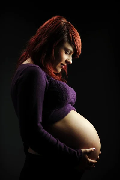 Mujer joven sosteniendo su barriga — Foto de Stock