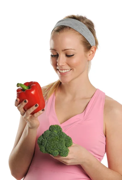 Mulher jovem segurando uma pimenta vermelha e brócolis — Fotografia de Stock