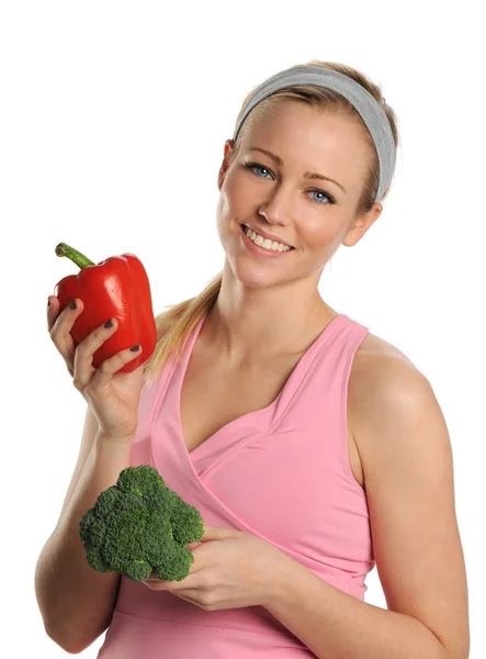 Mujer joven sosteniendo un pimiento rojo y brócoli — Foto de Stock