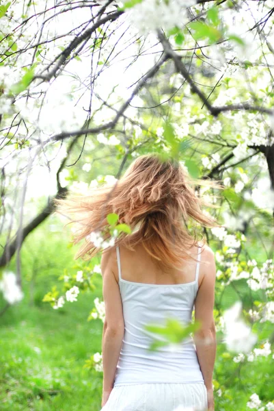 Vacker blond flicka i vårträdgård — Stockfoto