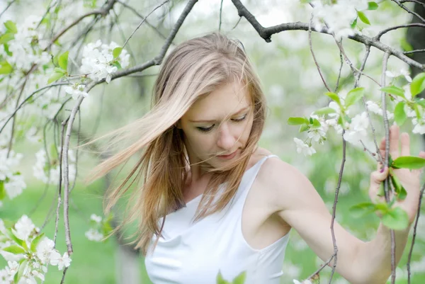 Vacker blond flicka i vårträdgård — Stockfoto