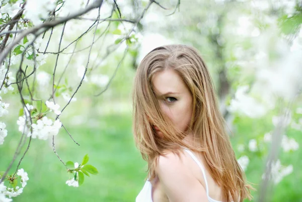 Vacker blond flicka i vårträdgård — Stockfoto