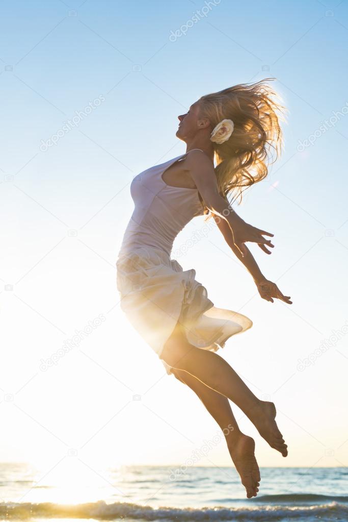 Happy Woman Jumping at the sea