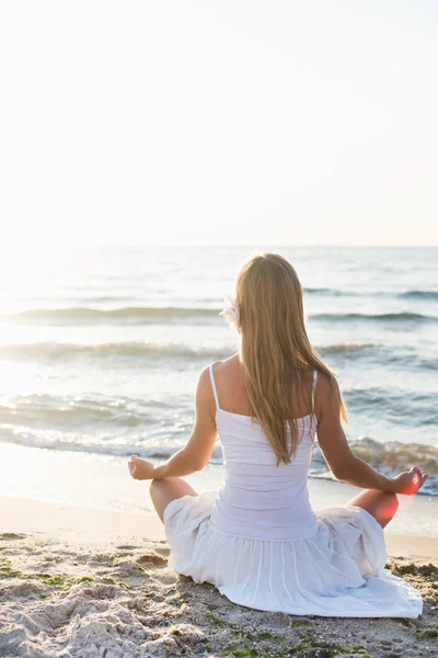 Junge Frau meditiert am Strand — Stockfoto