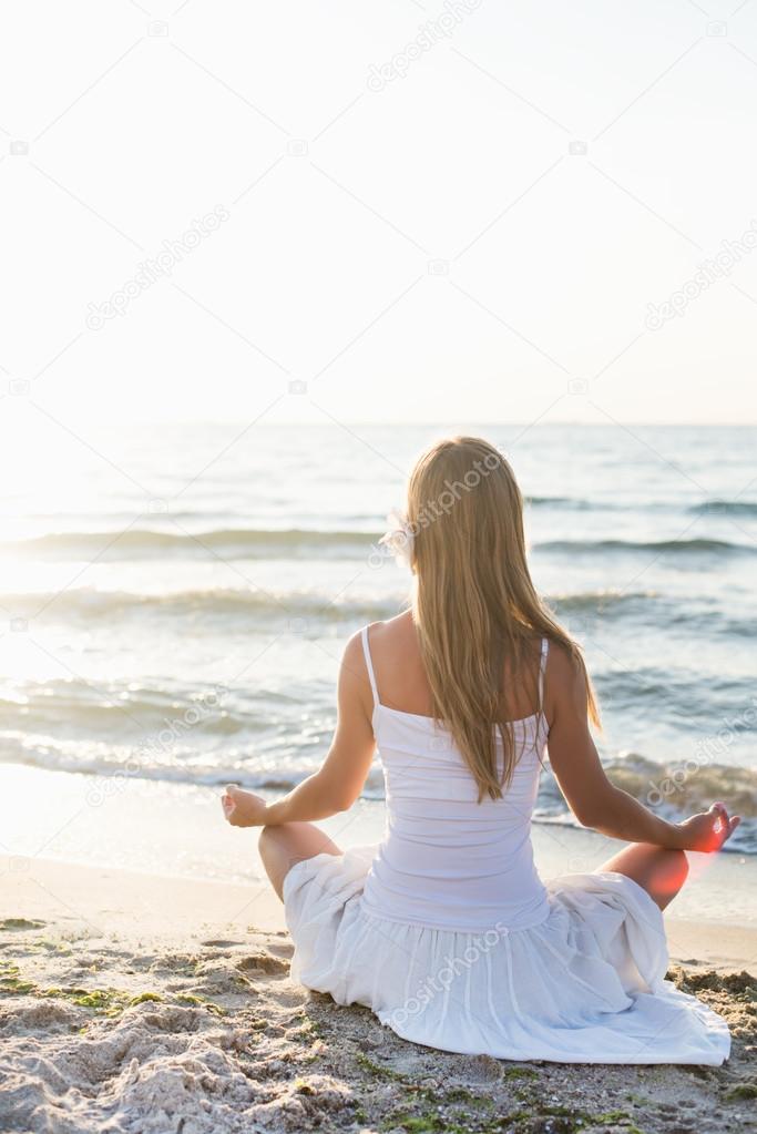 Young woman meditation on the beach