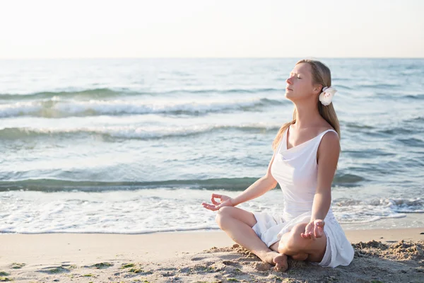 Молода жінка медитація на пляжі — стокове фото