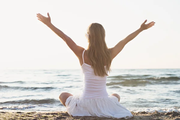 Ung kvinde meditation på stranden - Stock-foto