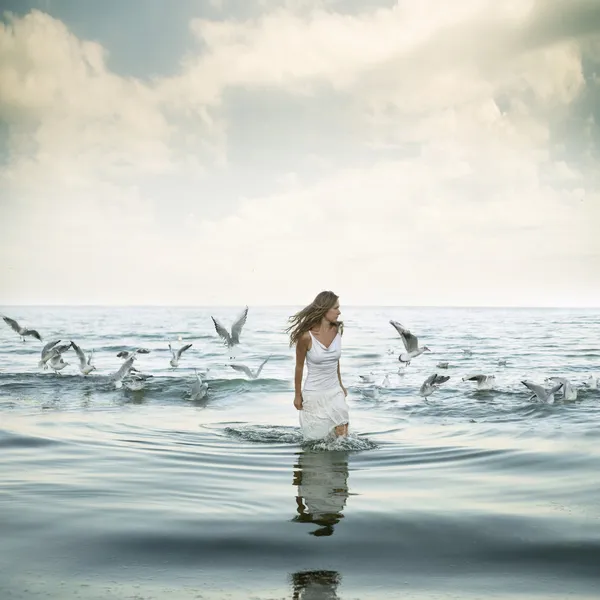 Beautiful woman and seaguls on the beach — Stock Photo, Image