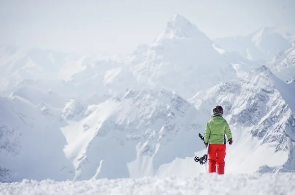 Kvinde snowboarder på bjergene - Stock-foto