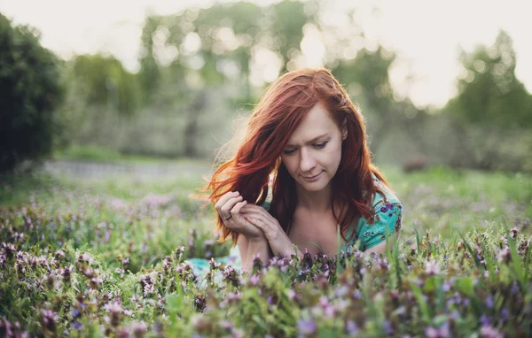 Flickan liggande i fältet blomma — Stockfoto